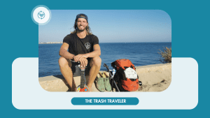 Mann am Strand mit "The Trash Traveler"-Logo auf Rucksack und T-Shirt, Gitarre in der Hand.