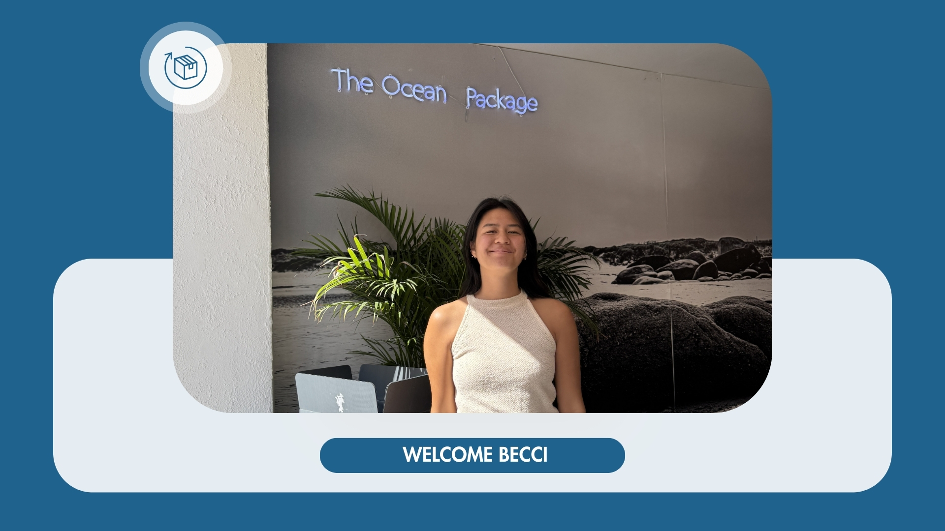 Becci, die neue Praktikantin bei The Ocean Package, lächelnd im Büro vor einer Wand mit Logo und Pflanzen.