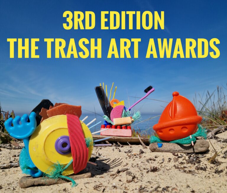 Trash Art Awards Kunstwerk aus gesammeltem Strandmüll (Plastik, Bürste, Flaschenteil) am Meer, als Beispiel für die Kreislaufwirtschaft.